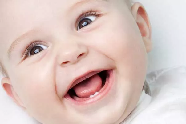Lachendes Baby mit erstem Zahn